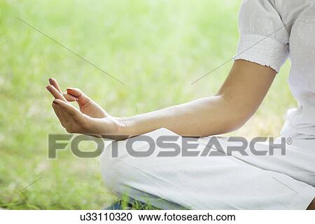 Stock Image - Close-up of a woman's hand in a meditative gesture . Fotosearch