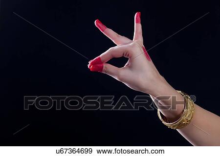Stock Photo - Close-up of a woman's hand making a Bharatanatyam gesture called Katakamukha on black background. Fotosearch