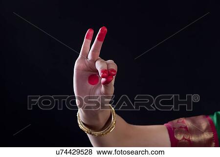 Stock Photo - Close-up of a woman's hand making a Bharatanatyam gesture called Katakamukha on black background. Fotosearch