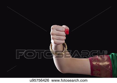 Stock Photograph - Close-up of a woman's hand making a Bharatanatyam gesture called Mushthi on black background. Fotosearch