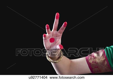 Picture - Close-up of a woman's hand making Bharatanatyam gesture called Sandamsha on black background. Fotosearch