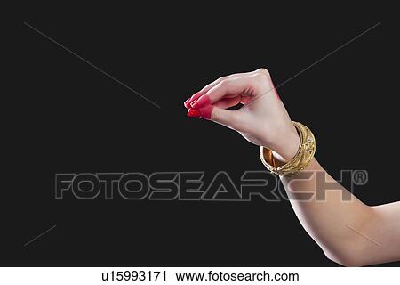 Stock Image - Close-up of a woman's hand making Bharatanatyam gesture called Mukula on black background. Fotosearch