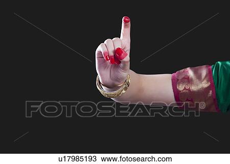 Stock Image - Close-up of a woman's hand making Bharatanatyam gesture called Tamrachuda on black background. Fotosearch