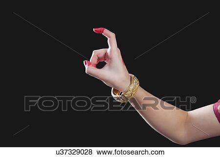 Stock Photo - Close-up of a woman's hand making Bharatanatyam gesture called Tamrachuda on black background. Fotosearch