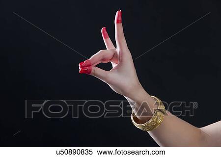 Stock Photography - Close-up of a woman's hand making Bharatanatyam gesture called Simhamukha on black background. Fotosearch