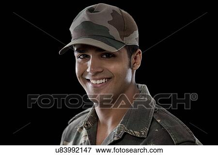 Stock Photo - Close-up of a young soldier smiling over black background . Fotosearch