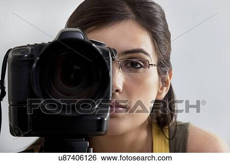 Stock Photograph - Close-up of a young woman taking a photograph . Fotosearch