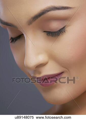 Close-up of a young woman with eyes closed over colored background View Large Photo Image Stock Photography - Close-up of a young woman with eyes closed over colored background . Fotosearch