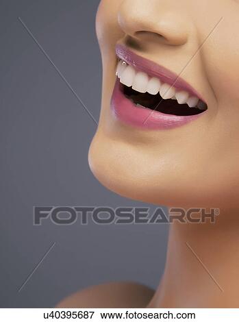 Close-up of a young woman's beautiful smile over colored background View Large Photo Image Stock Photo - Close-up of a young woman's beautiful smile over colored background . Fotosearch