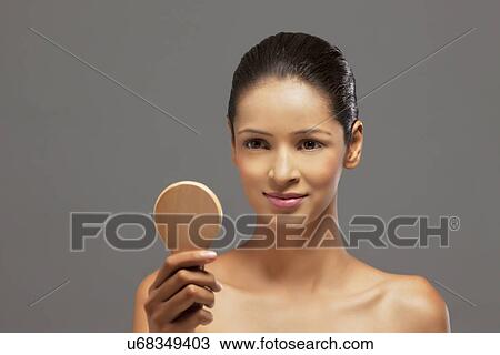 Close-up of beautiful young woman with a hand mirror View Large Photo Image Stock Image - Close-up of beautiful young woman with a hand mirror . Fotosearch