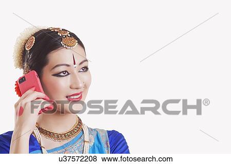 Stock Photo - Close-up of Bharatanatyam dancer using mobile phone over white background. Fotosearch