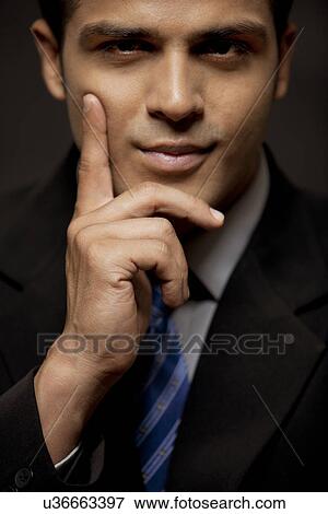 Close-up of confident business man with hand on chin View Large Photo Image Stock Photo - Close-up of confident business man with hand on chin . Fotosearch