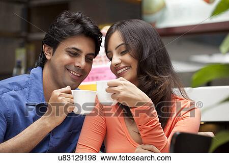 Stock Photo - Close-up of couple enjoying their tea together in shopping mall . Fotosearch