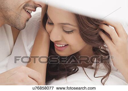 Close-up of couple romancing in bed View Large Photo Image Stock Photo - Close-up of couple romancing in bed. Fotosearch