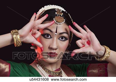 Stock Photo - Close-up of furious dancer performing Bharatanatyam on black background. Fotosearch