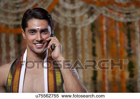 Stock Photography - Close-up of groom having conversation on mobile phone . Fotosearch