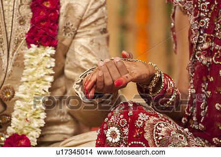 Close-up of groom holding brides hand View Large Photo Image Picture - Close-up of groom holding brides hand . Fotosearch