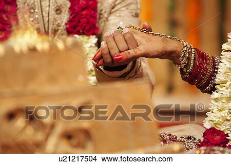 Close-up of groom holding brides hand View Large Photo Image Picture - Close-up of groom holding brides hand . Fotosearch