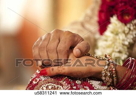 Close-up of groom holding brides hand View Large Photo Image Stock Image - Close-up of groom holding brides hand . Fotosearch