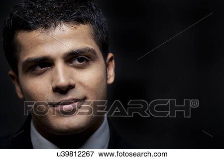 Close-up of handsome business man contemplating over black background View Large Photo Image Stock Photo - Close-up of handsome business man contemplating over black background . Fotosearch