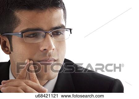 Close-up of handsome businessman contemplating over white background View Large Photo Image Stock Image - Close-up of handsome businessman contemplating over white background . Fotosearch