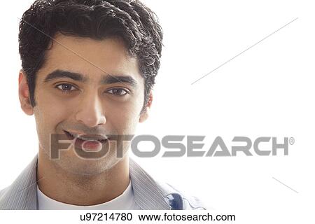 Stock Image - Close-up of handsome young man smiling over white background . Fotosearch