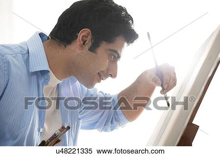Stock Photography - Close-up of happy male painter painting in art studio . Fotosearch