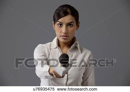 Close-up of serious reporter holding out microphone View Large Photo Image Stock Photography - Close-up of serious reporter holding out microphone . Fotosearch