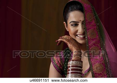 Stock Image - Close-up of smiling beautiful young woman in bridal wear . Fotosearch