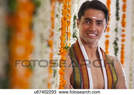 Close-up of smiling groom standing near garland View Large Photo Image Stock Image - Close-up of smiling groom standing near garland . Fotosearch
