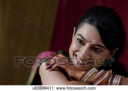 Close-up of smiling young Indian bride with arms crossed View Large Photo Image Stock Image - Close-up of smiling young Indian bride with arms crossed . Fotosearch