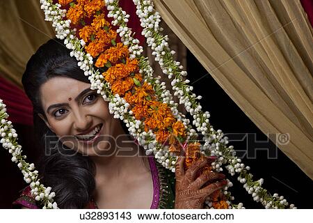 Close-up of smiling young Indian woman looking away with wreath View Large Photo Image Stock Image - Close-up of smiling young Indian woman looking away with wreath . Fotosearch