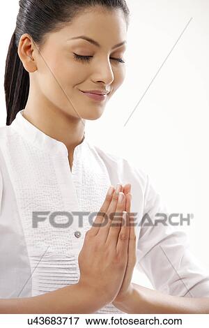 Stock Photo - Close-up of smiling young woman meditating . Fotosearch