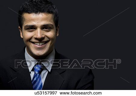 Stock Photo - Close-up of successful business man smiling over black background . Fotosearch
