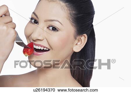 Close-up of woman eating strawberry over white background View Large Photo Image Stock Image - Close-up of woman eating strawberry over white background . Fotosearch