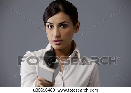 Close-up of woman holding microphone against colored background View Large Photo Image Stock Photo - Close-up of woman holding microphone against colored background . Fotosearch
