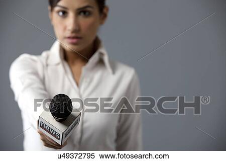 Stock Photography - Close-up of woman reporter holding microphone . Fotosearch