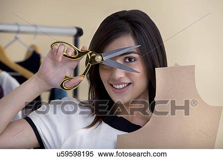 Close-up of young fashion designer holding scissors and cardboard View Large Photo Image Stock Photography - Close-up of young fashion designer holding scissors and cardboard . Fotosearch