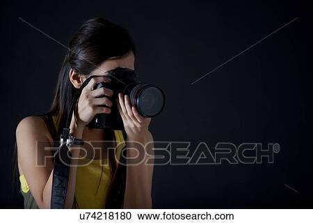 Close-up of young female photographer taking a photograph View Large Photo Image Stock Image - Close-up of young female photographer taking a photograph . Fotosearch
