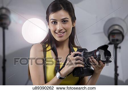 Close-up of young female photographer with digital camera in studio View Large Photo Image Stock Image - Close-up of young female photographer with digital camera in studio . Fotosearch