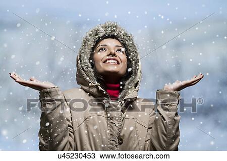 Stock Image - Close-up of young woman enjoying snow . Fotosearch