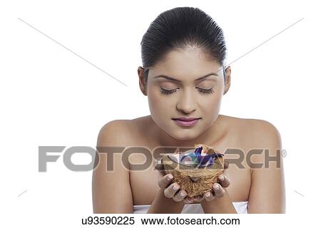 Close-up of young woman holding coconut over white background View Large Photo Image Stock Photography - Close-up of young woman holding coconut over white background . Fotosearch