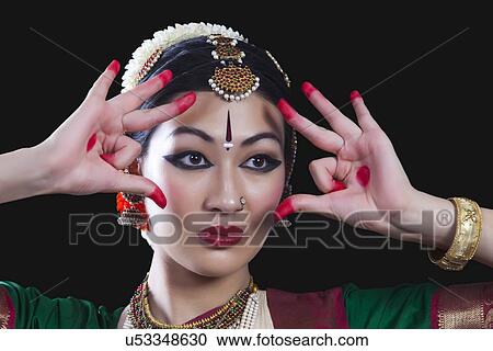 Close-up of young woman making Bharatanatyam gesture called Shakatam on black background View Large Photo Image Stock Image - Close-up of young woman making Bharatanatyam gesture called Shakatam on black background. Fotosearch