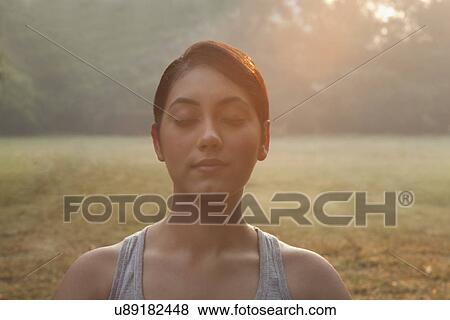 Stock Photo - Close-up of young woman meditating . Fotosearch