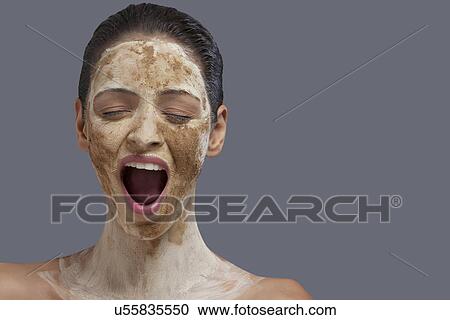 Stock Image - Close-up of young woman with cosmetic mask . Fotosearch