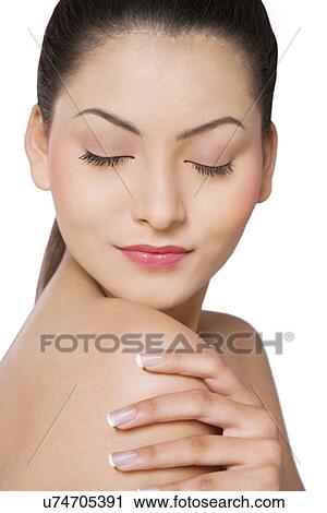 Close-up of young woman with eyes closed touching her shoulder View Large Photo Image Stock Image - Close-up of young woman with eyes closed touching her shoulder . Fotosearch