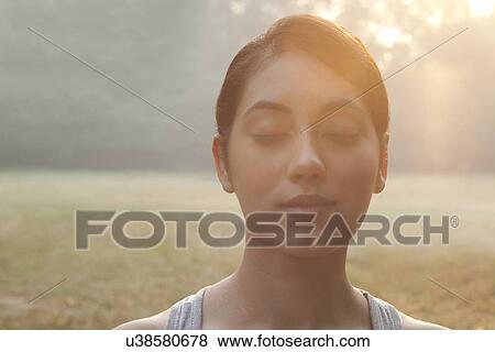 Stock Photo - Close-up of young woman with eyes closed . Fotosearch