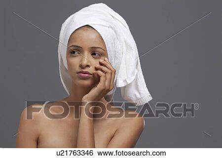 Close-up of young woman with towel on head looking away View Large Photo Image Stock Photograph - Close-up of young woman with towel on head looking away . Fotosearch