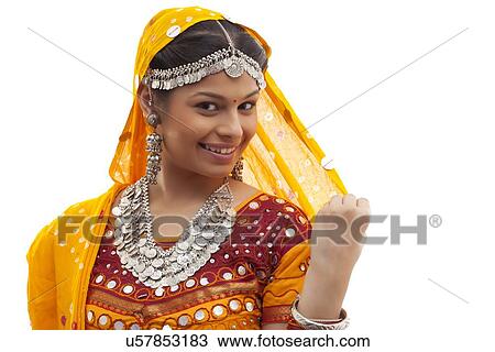 Close-up portrait of happy young woman wearing choli and dupatta over white background View Large Photo Image Stock Image - Close-up portrait of happy young woman wearing choli and dupatta over white background. Fotosearch
