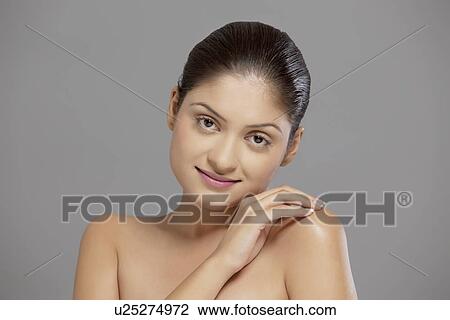 Stock Image - Close-up portrait of pretty woman over grey background . Fotosearch